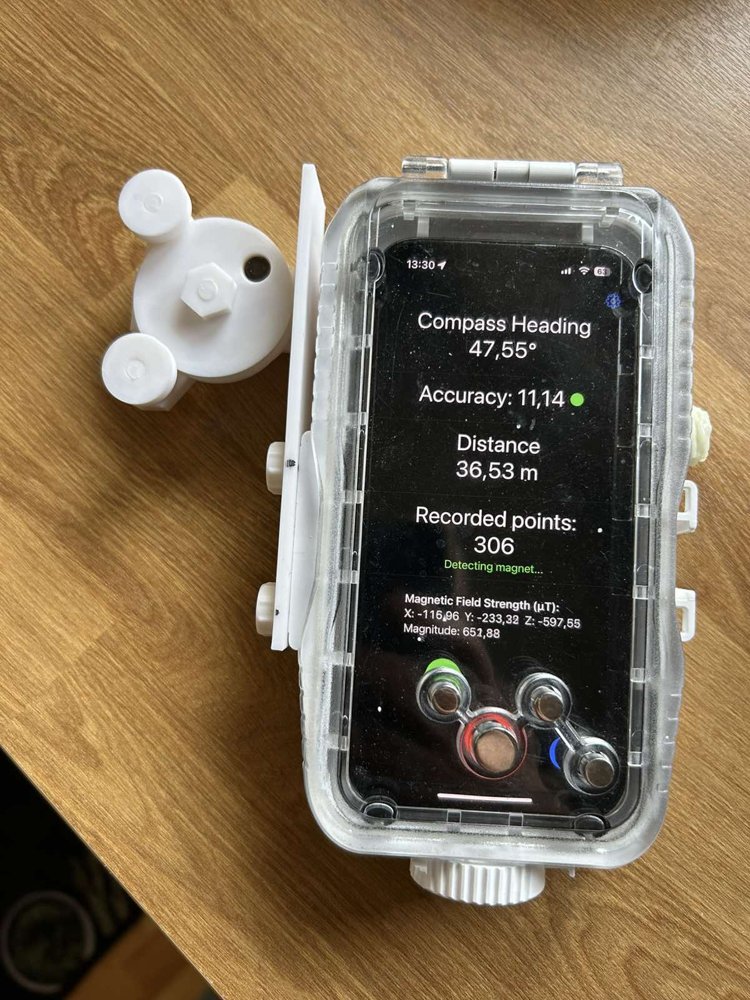 iPhone in a clear dive housing running CaveDiveMap, with the white 3D-printed measuring wheel device attached